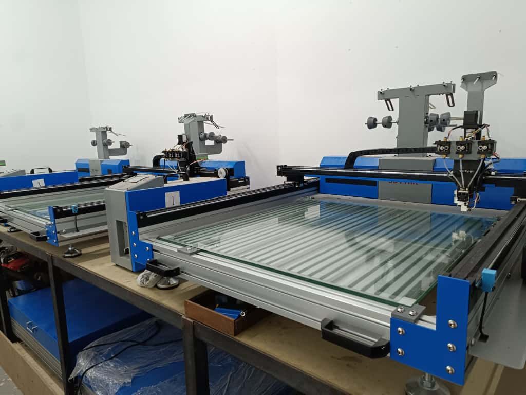 Una impresora 3D imprime un trozo de plástico sobre una superficie metálica.