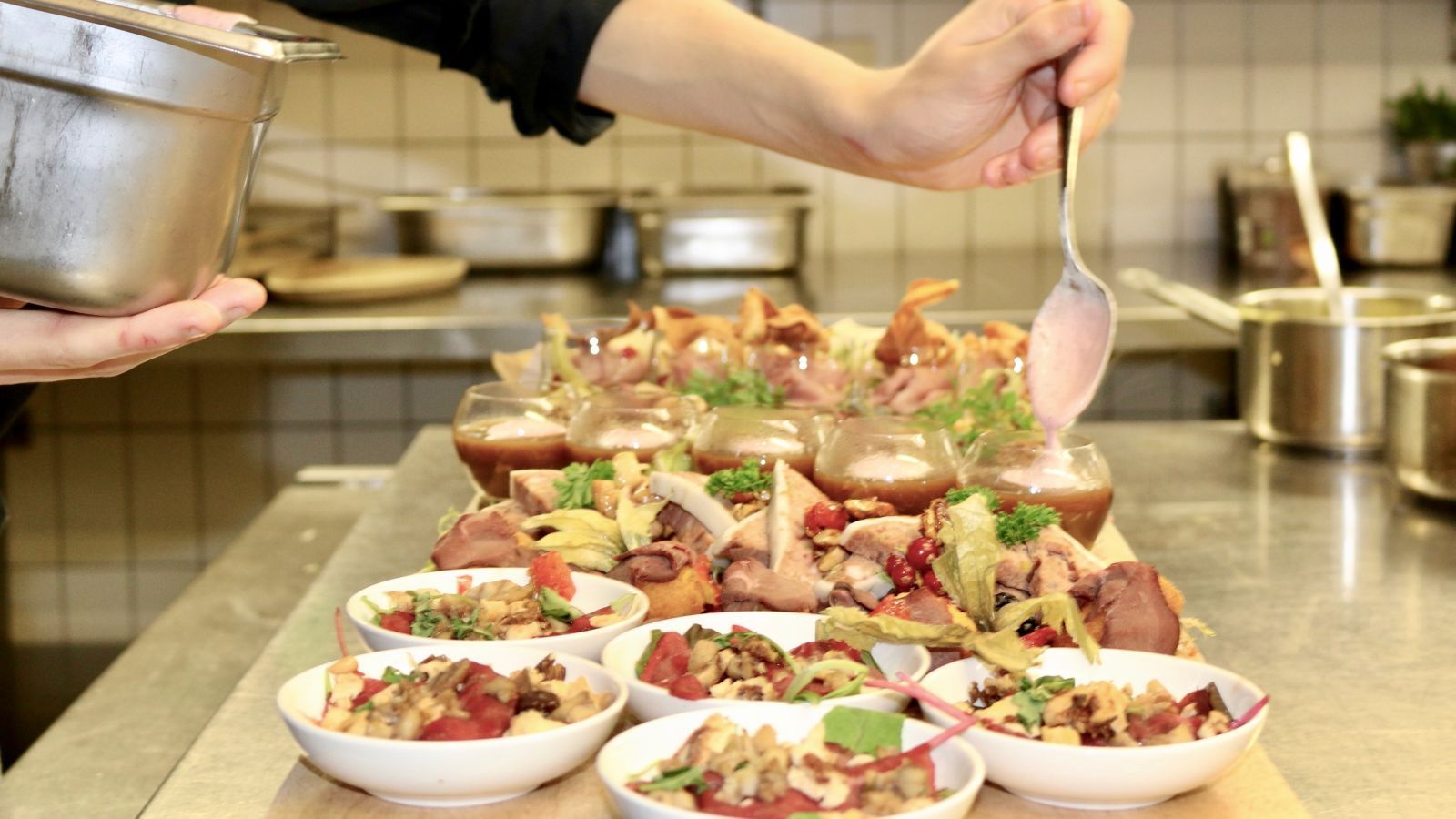 Der Koch garniert Vorspeisen auf einer Küchentheke.