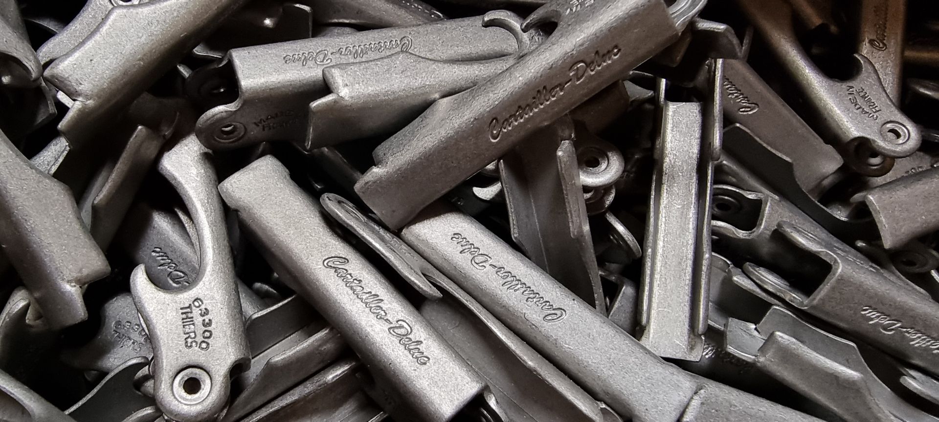Un tas d'outils à main en métal de tons gris et noirs assortis, se chevauchant étroitement.