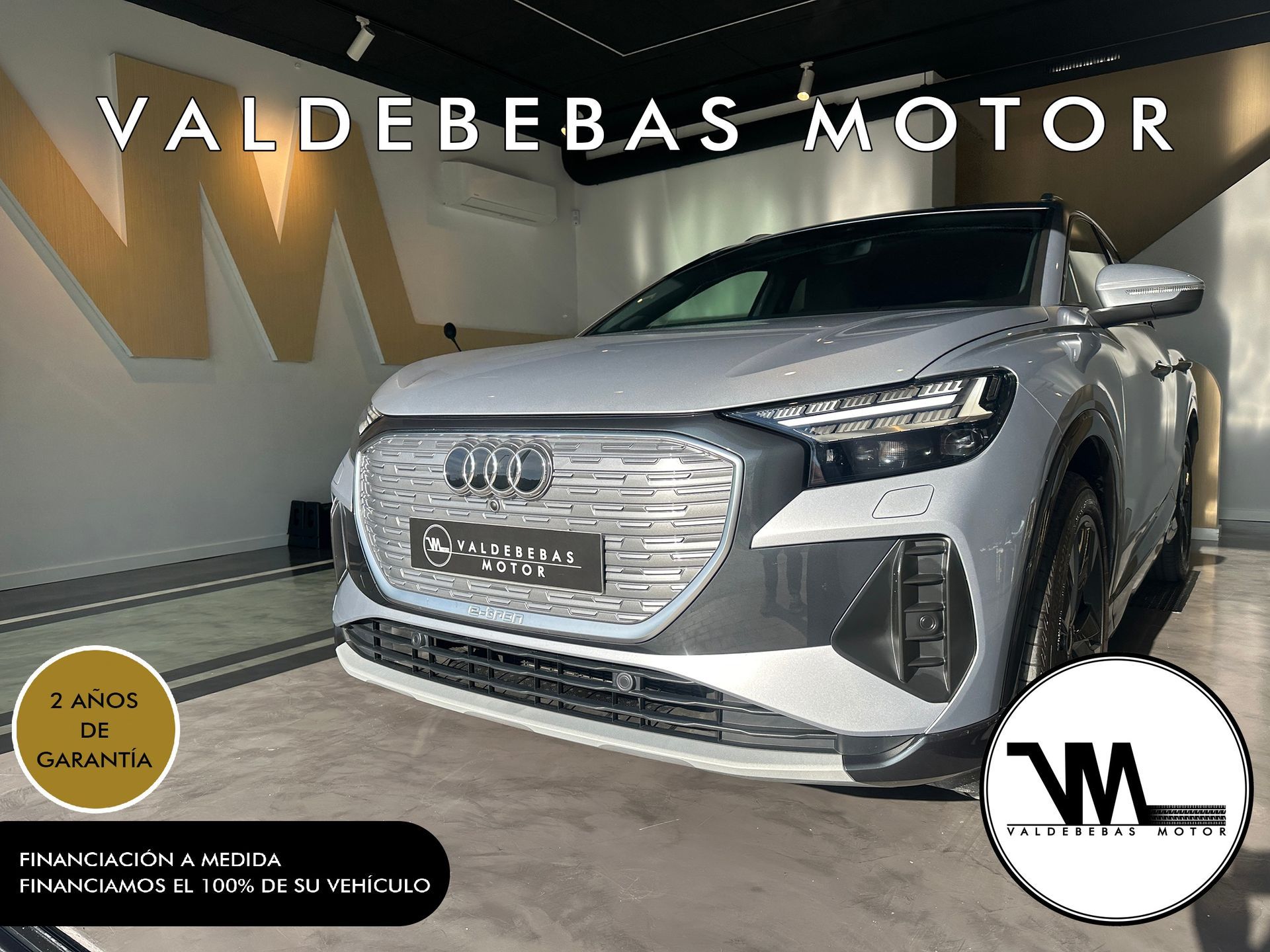 Un Audi Q4 e-tron blanco está estacionado en una sala de exposición.
