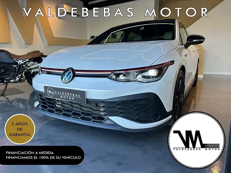 Un Volkswagen Golf blanco está en una sala de exposición.