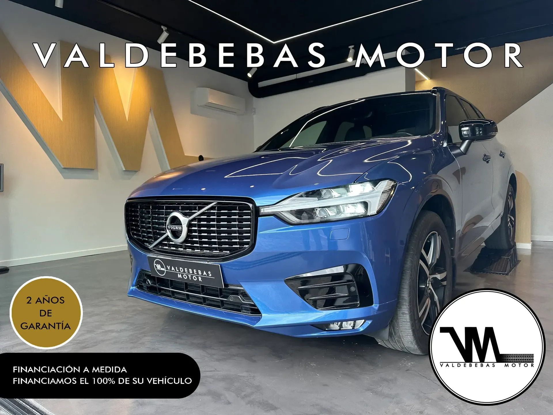 Un coche Volvo azul está aparcado en una sala de exposición.