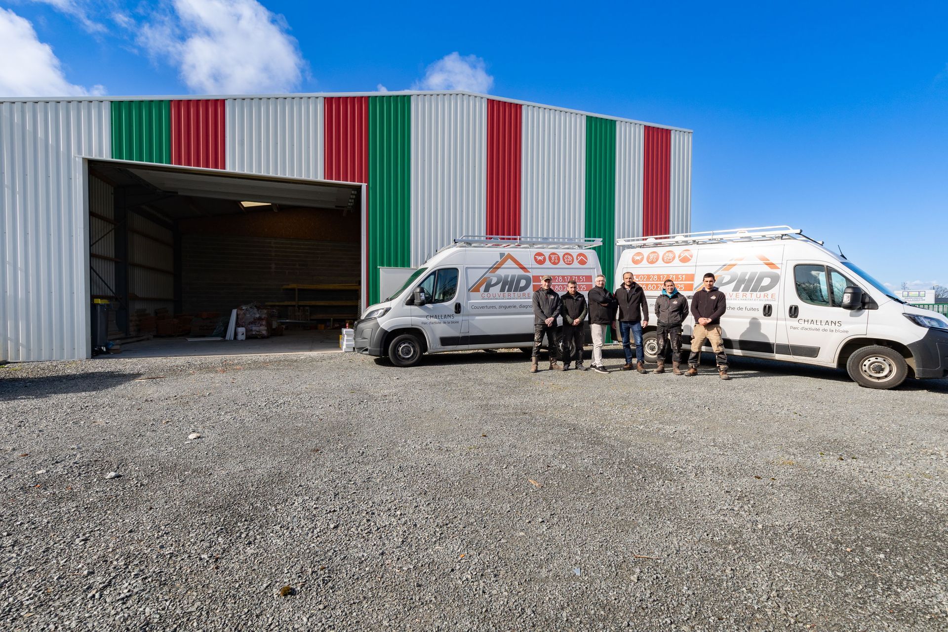 Toute l'équipe de PHD posant devant l'entrepôt et les camions