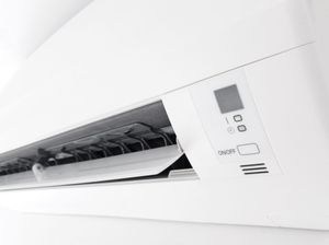 Climatiseur mural blanc avec grille d'aération frontale et panneau de commande numérique