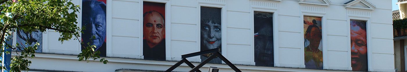 Ein weißes Gebäude mit Gemälden an den Fenstern und Türen