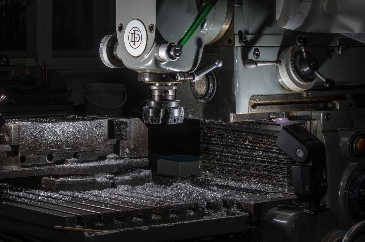 Fresadora de metal en funcionamiento, cortando metal. Virutas de metal rodean la pieza.