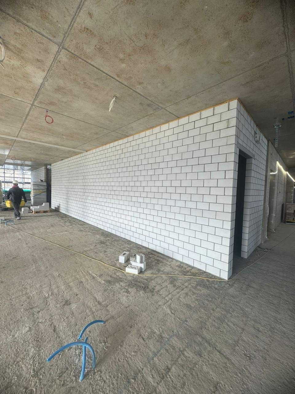 Intérieur d'un chantier de construction avec des murs en parpaings blancs.