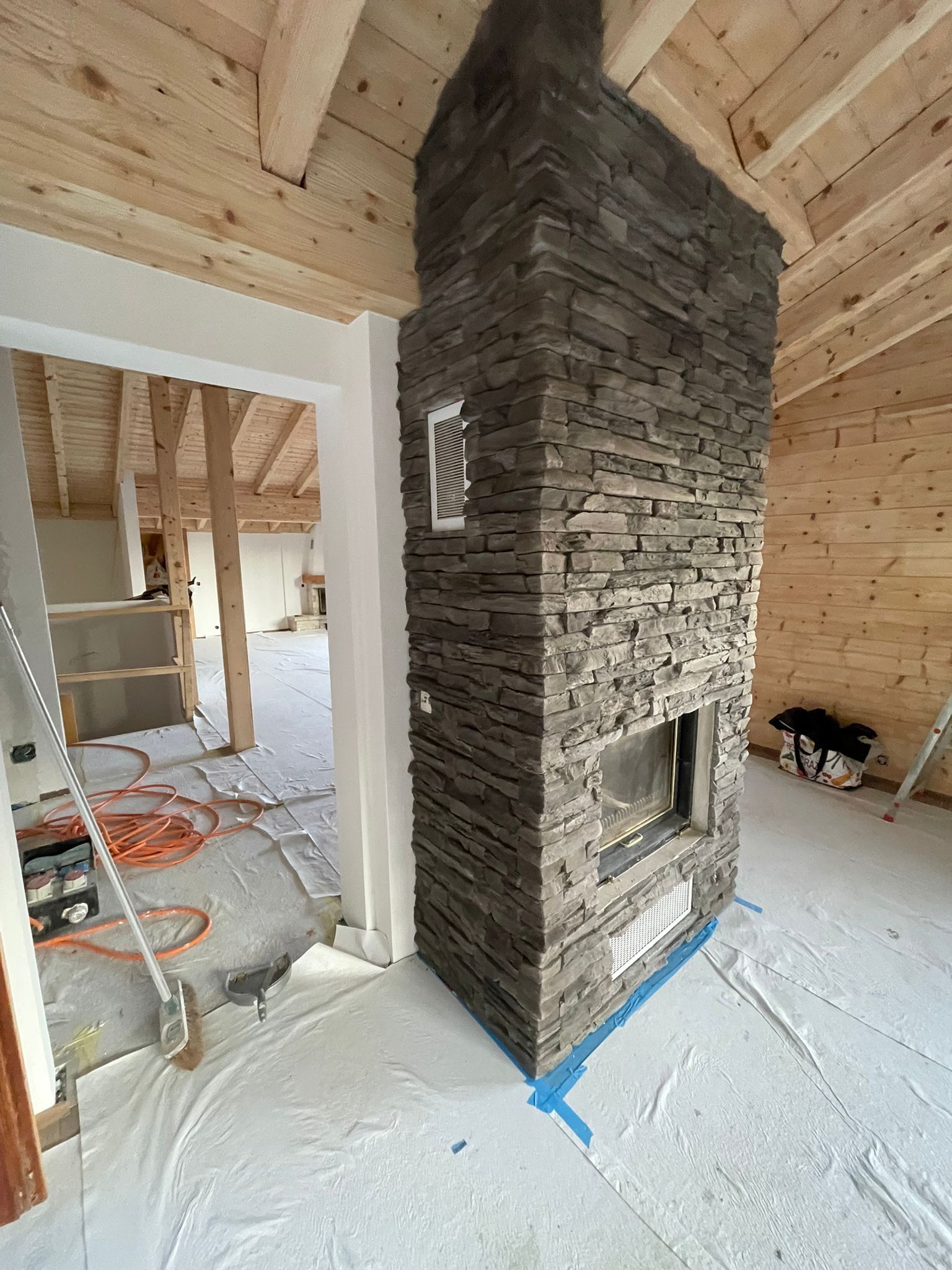 Salle à manger avec petite table ronde, chaises blanches, éclairage au plafond et porte blanche.