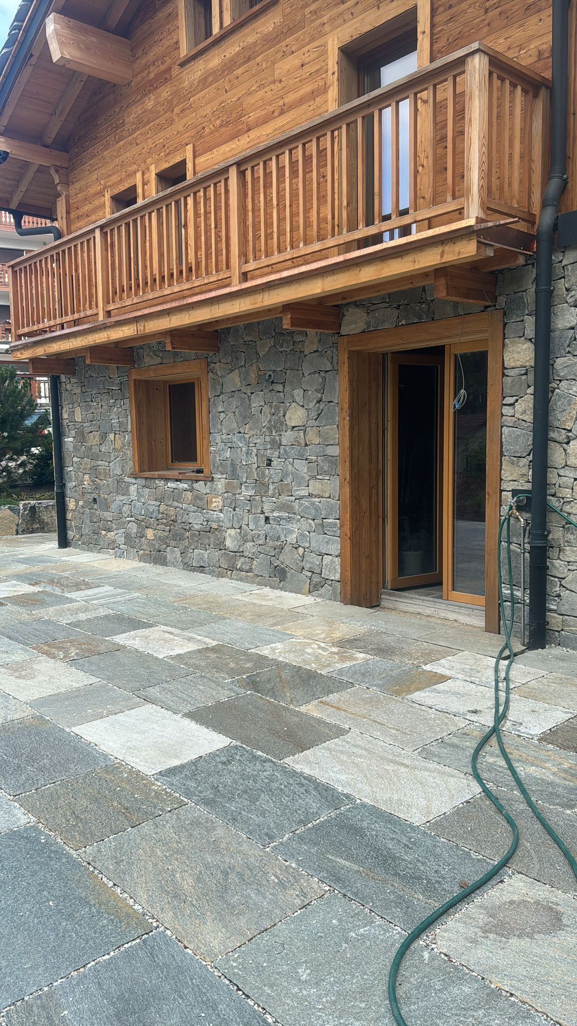 Bâtiment en construction avec échafaudages, tas de terre et un ciel bleu dégagé.