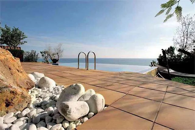 Hay una piscina con vista al mar.