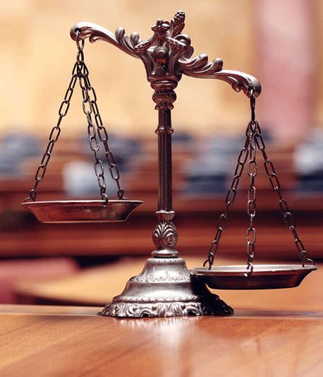 Una balanza de la justicia se encuentra sobre una mesa de madera