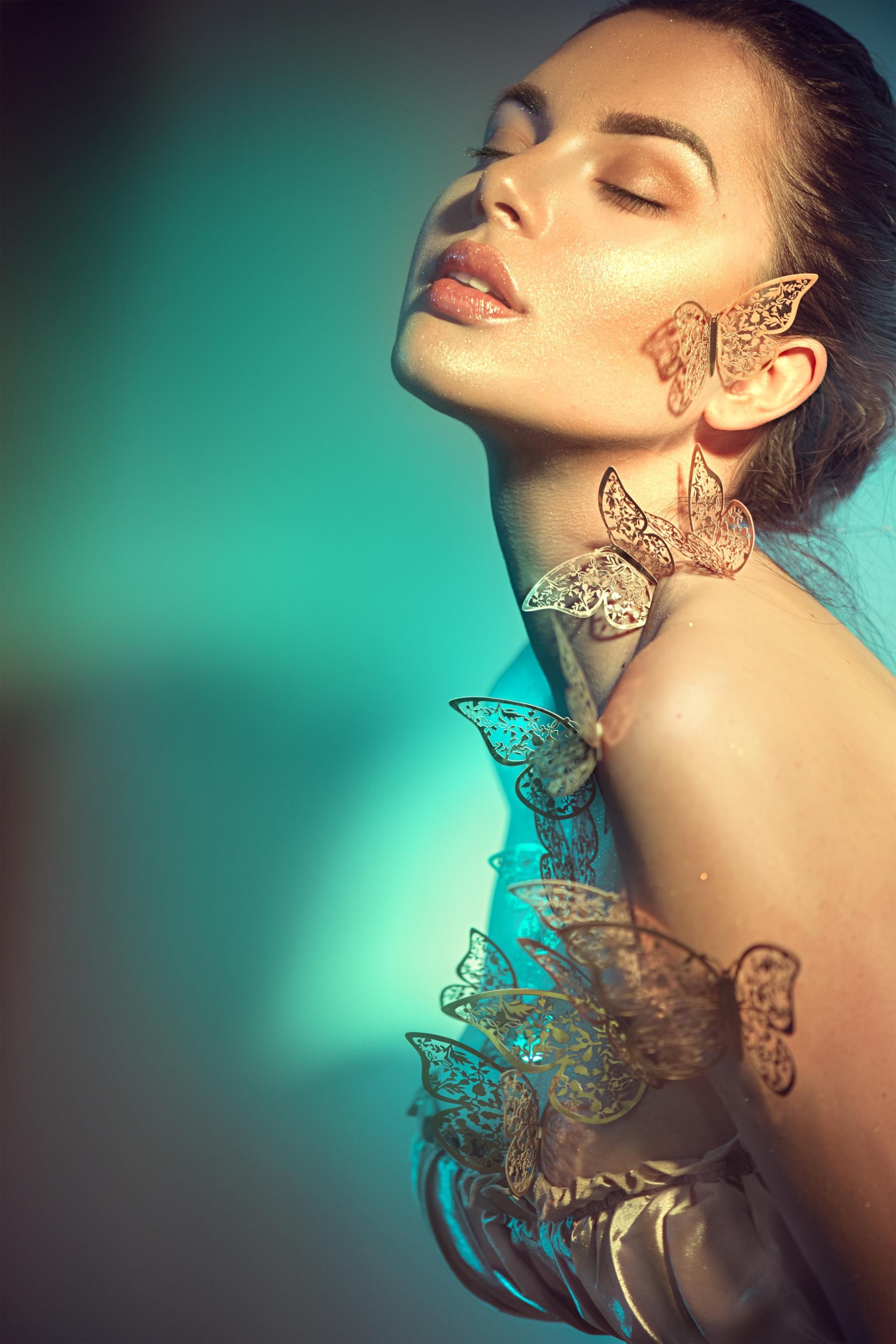 Junge Frau mit goldenem Make-Up und Schmetterlingen