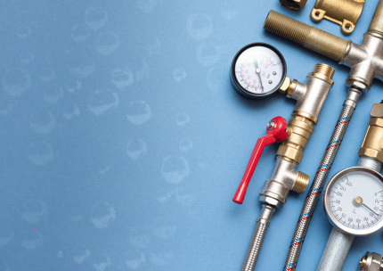 Un tas de tuyaux de plomberie et de jauges sur fond bleu.
