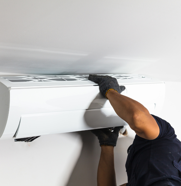 Un homme installe un climatiseur sur le mur