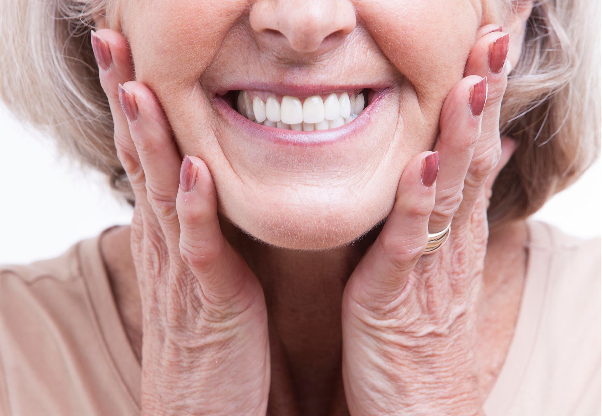 Dentista combinando a tonalidade de uma faceta com os dentes do paciente em um consultório odontológico.