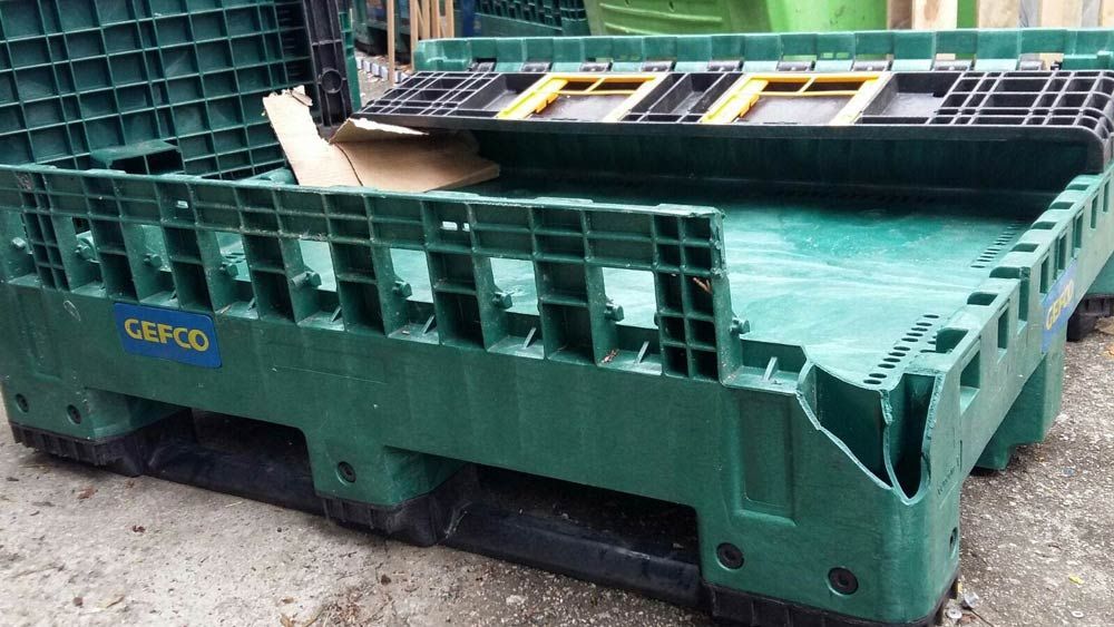 Una caja de plástico verde con una etiqueta azul que dice cerco