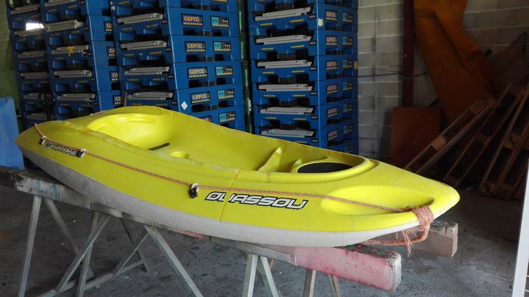 Un kayak amarillo está sobre una mesa en un garaje.