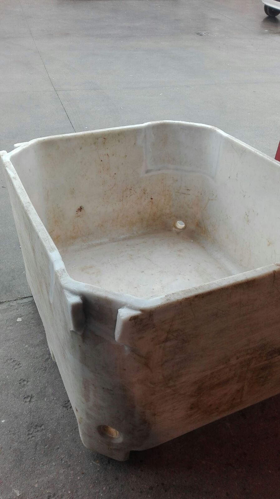 Un gran contenedor blanco está en el suelo.