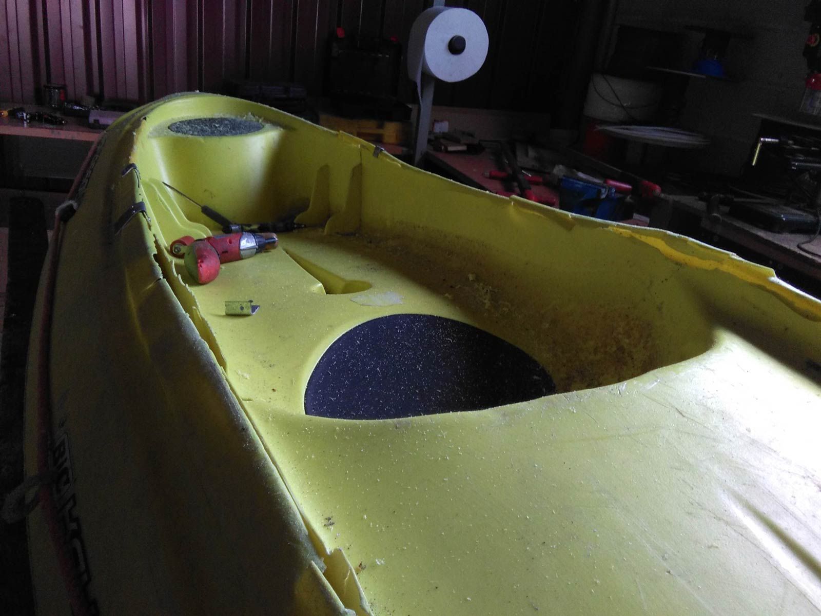 Un kayak amarillo está sobre una mesa en una habitación oscura.