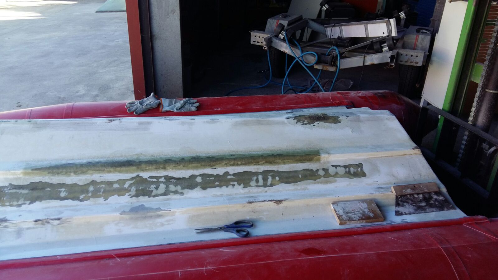 Un coche rojo está estacionado en un garaje con un trozo de papel encima.