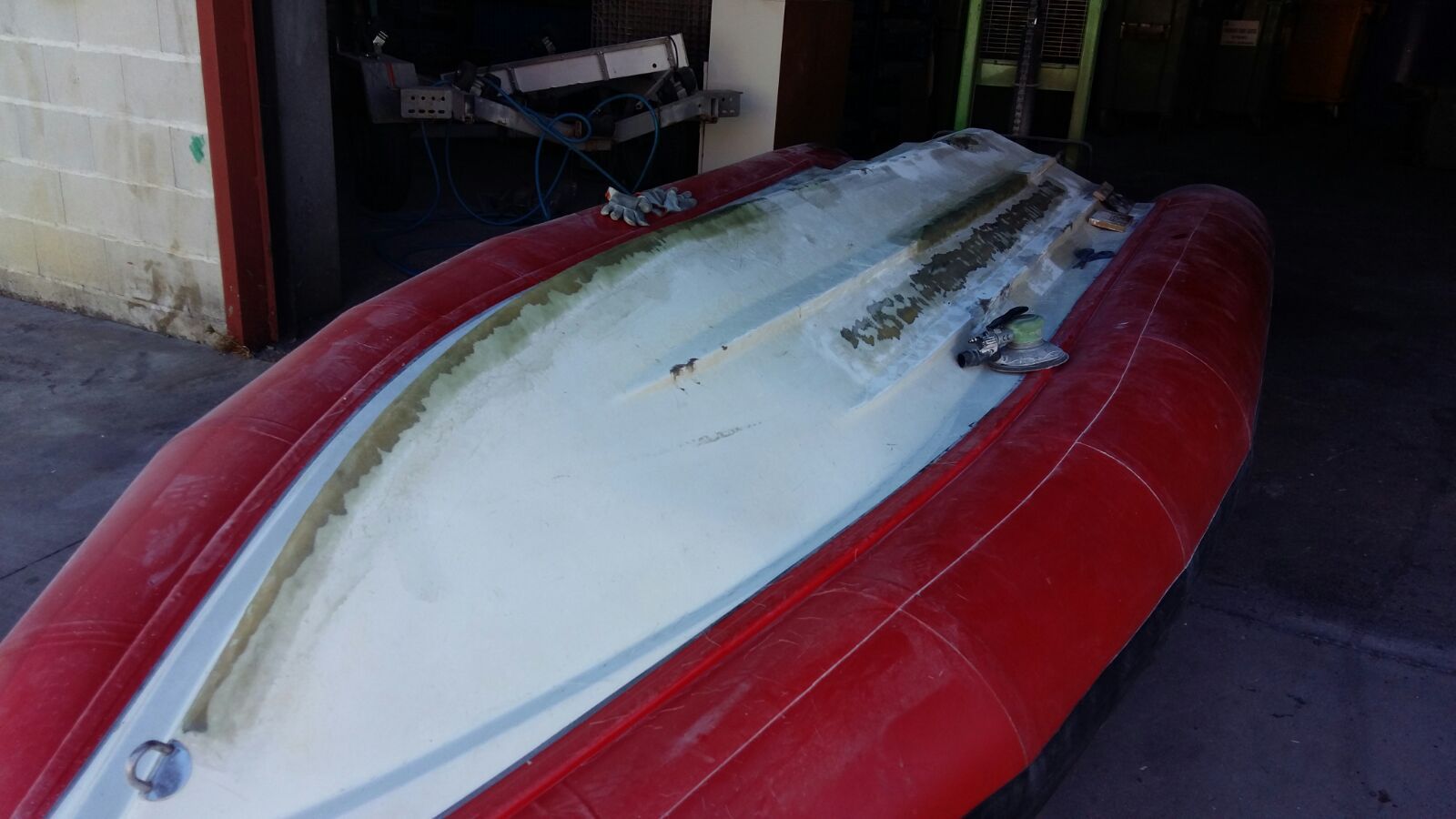 Un barco rojo y blanco está estacionado en un garaje.