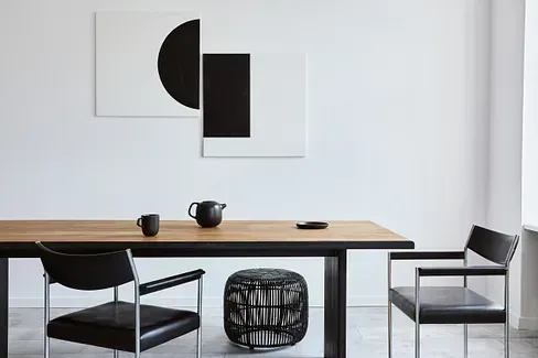 Un comedor con una mesa y sillas y un cuadro en la pared.
