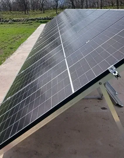 Una fila de paneles solares colocados sobre una superficie de hormigón.