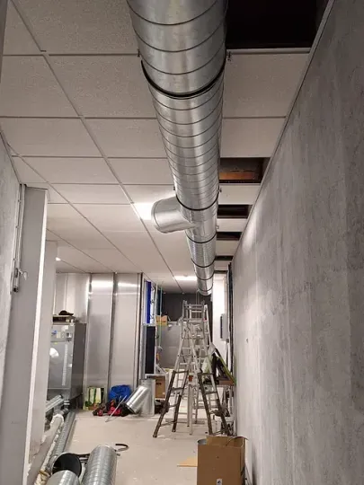 Un gran tubo de metal cuelga del techo de un edificio.