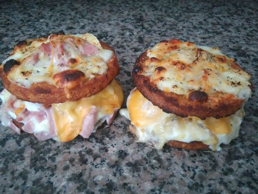 Deux sandwichs pour le petit-déjeuner, le dessus grillé, posés sur un comptoir moucheté.