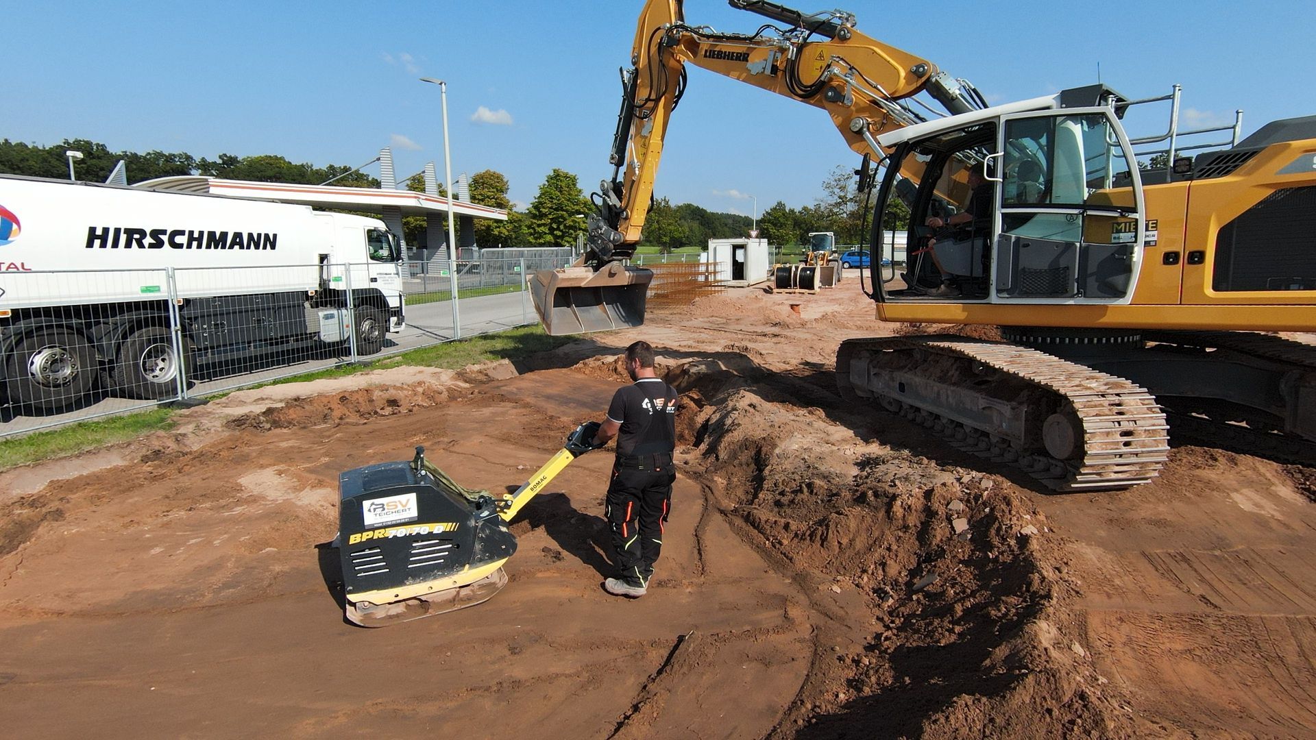 Ein gelber Bulldozer ebnet die Erde auf einer Baustelle.