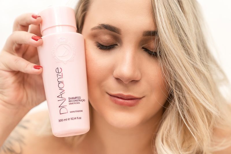 Donna posa accanto a prodotti di bellezza