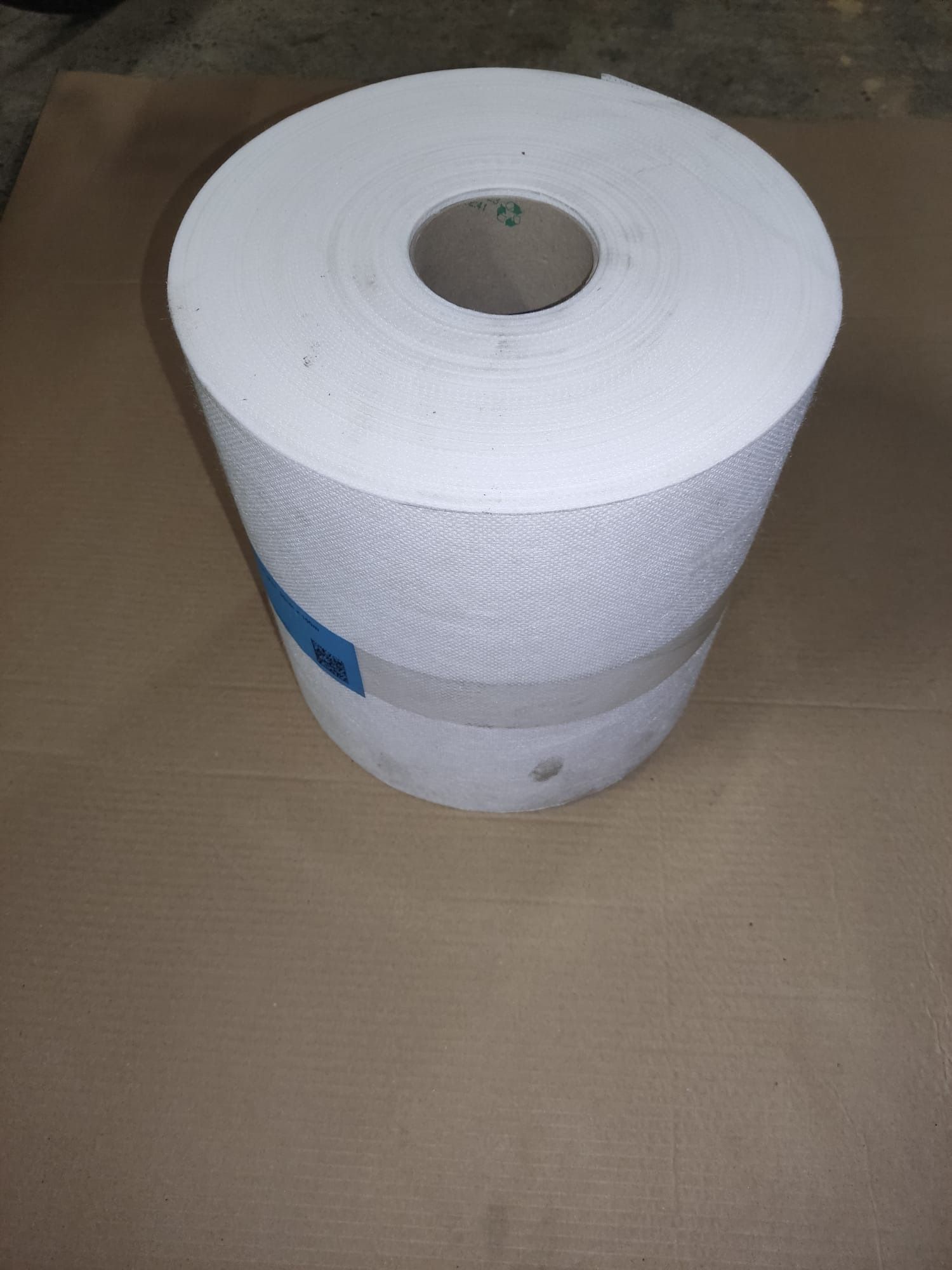 Rollo de papel de cocina blanco sobre una superficie marrón