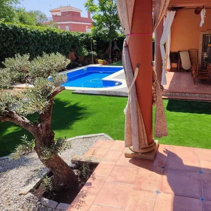 Una gran piscina está en el patio trasero de una casa.