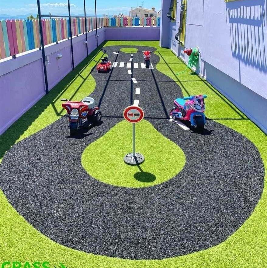 Una motocicleta de juguete y un coche de juguete están en un camino cubierto de hierba.