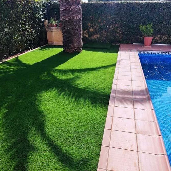 Una piscina rodeada de un exuberante césped verde