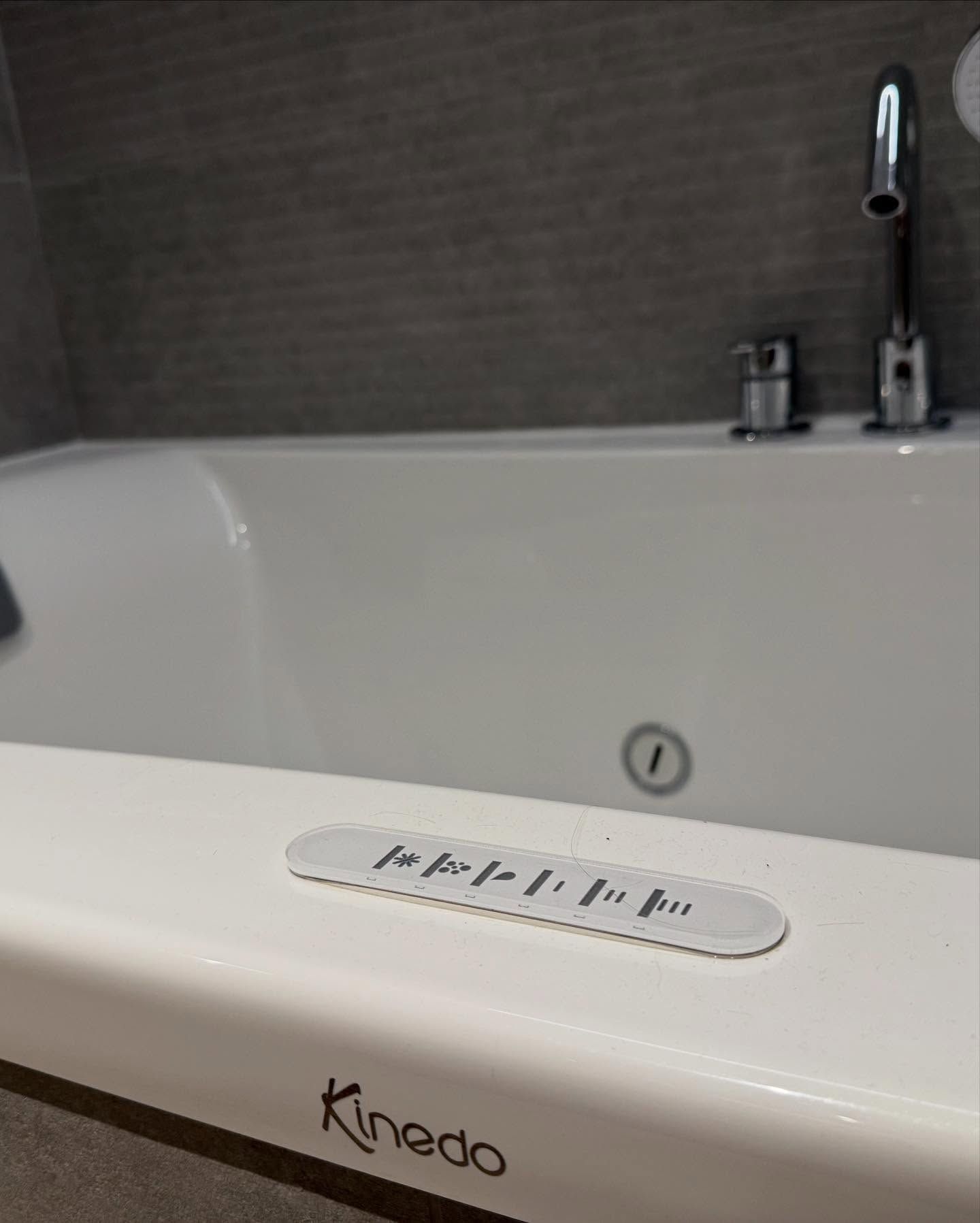 Baignoire Jacuzzi blanche dans une salle de bains avec robinetterie et panneau de commande chromés.