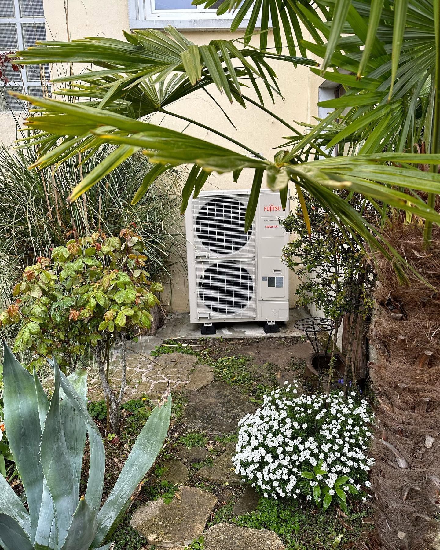 Unité de climatisation extérieure à côté d'une maison.