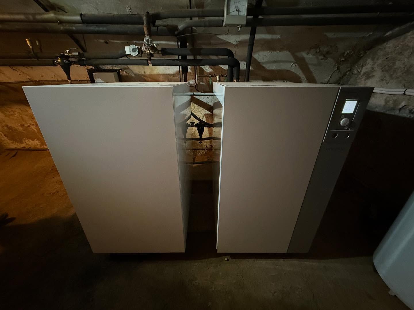 Deux grandes PAC dans un sous-sol, l'un d'eux ayant un panneau de commande sur la droite.