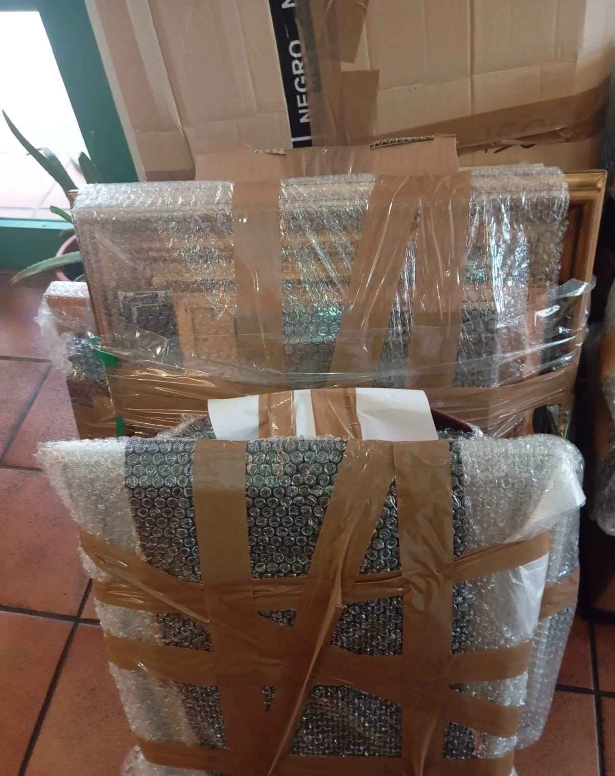 Camiones de mudanza blancos estacionados frente a un edificio con la etiqueta 