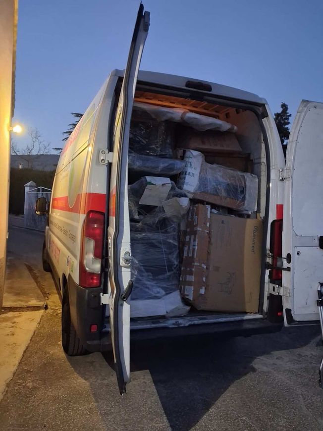 Camiones de mudanza blancos estacionados frente a un edificio con la etiqueta 