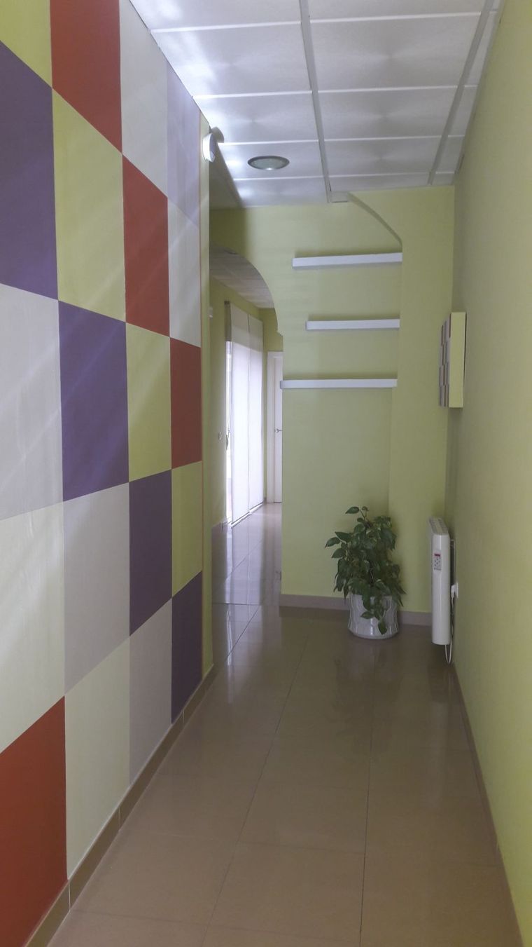 Un pasillo largo con una planta en el medio.