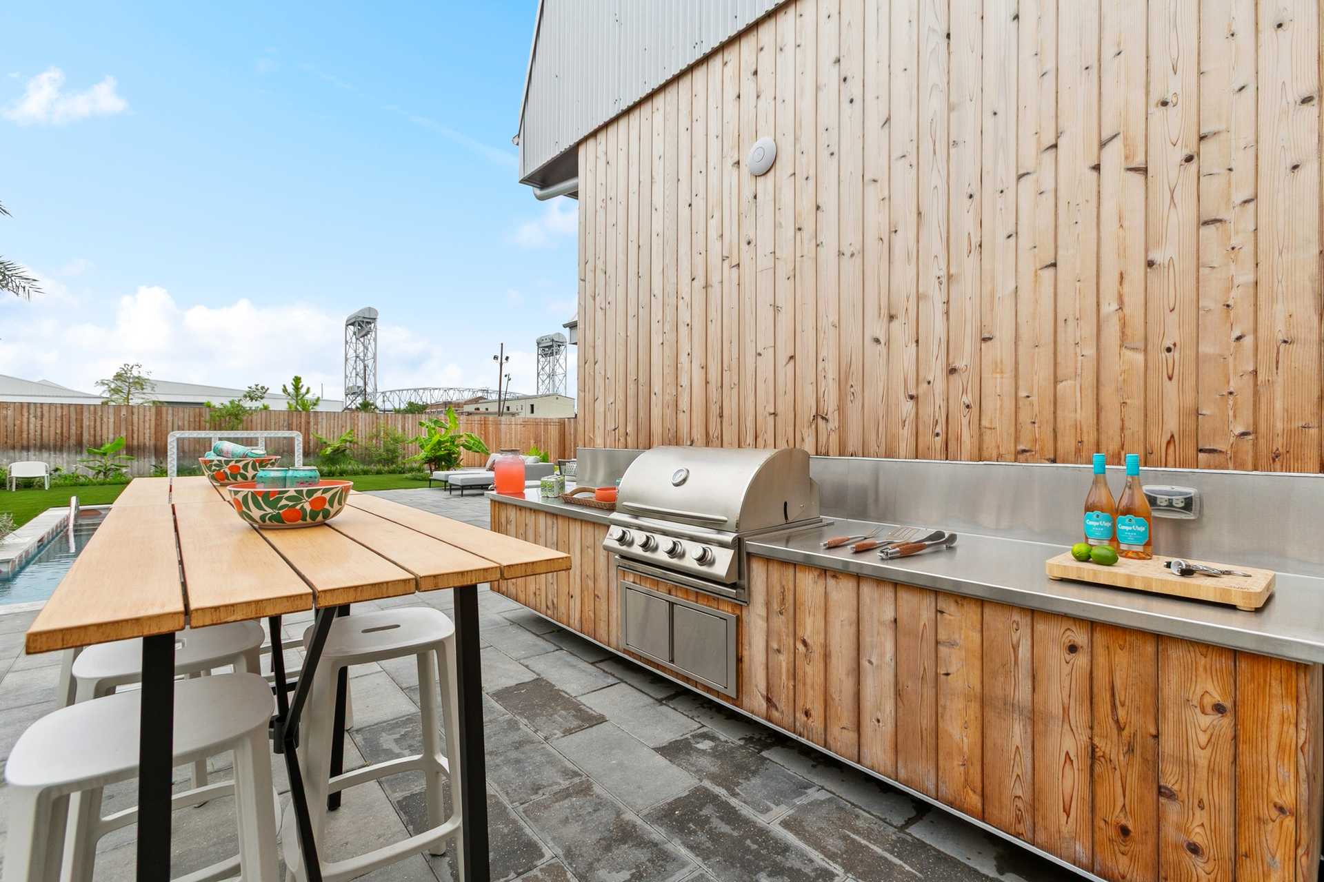 Outdoor kitchen with grill, countertop, and wooden table.