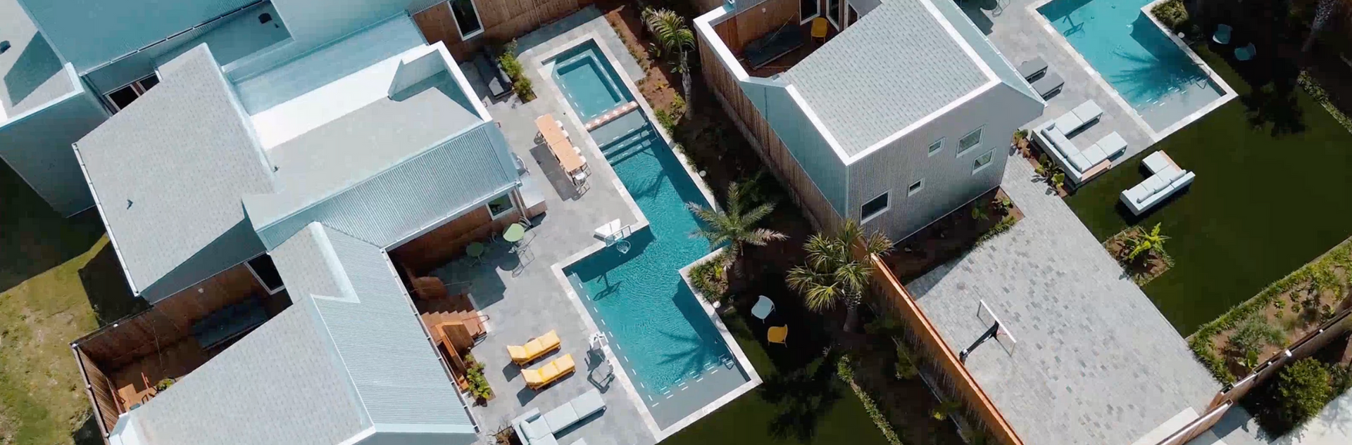 Aerial view of modern homes with pools and artificial turf lawns.