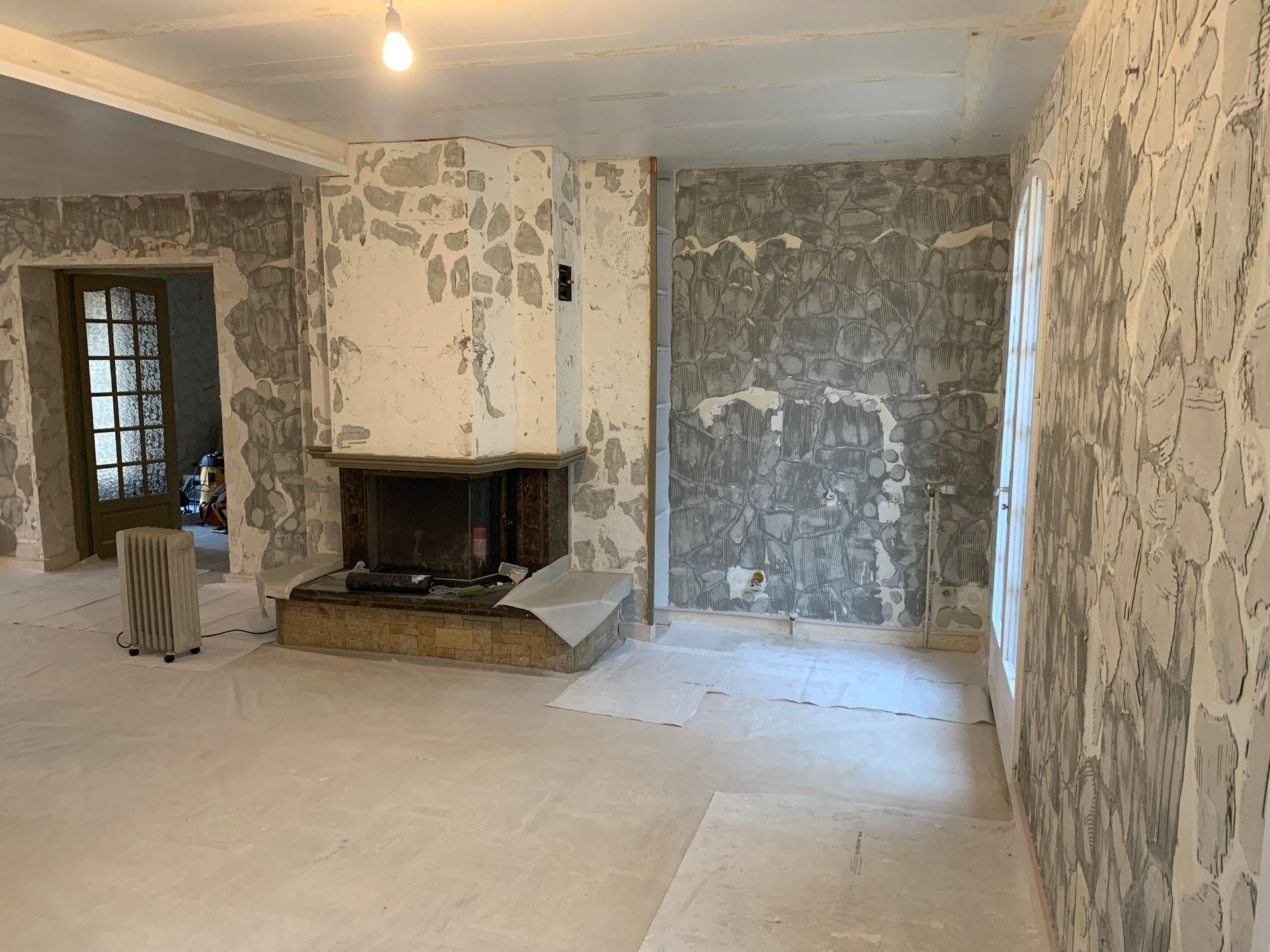 Salon avant les travaux de peinture intérieure avec murs en pierre