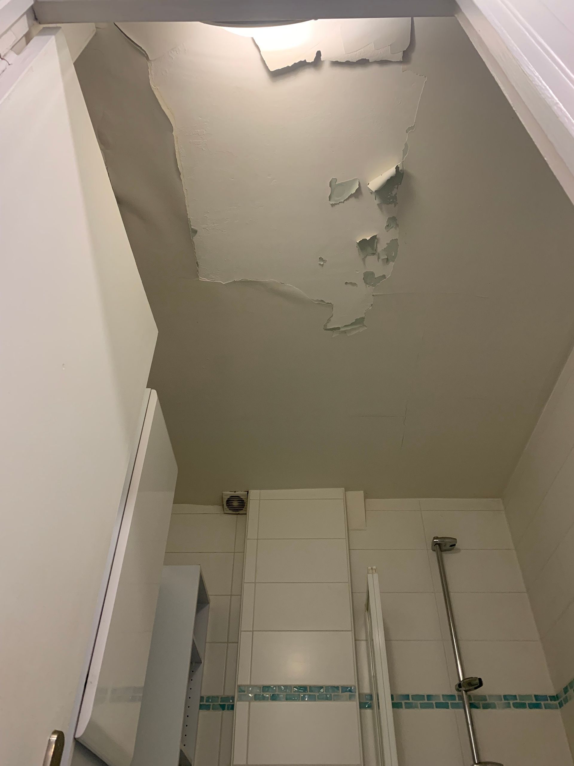 Plafond avec de la peinture écaillée dans une salle de bains