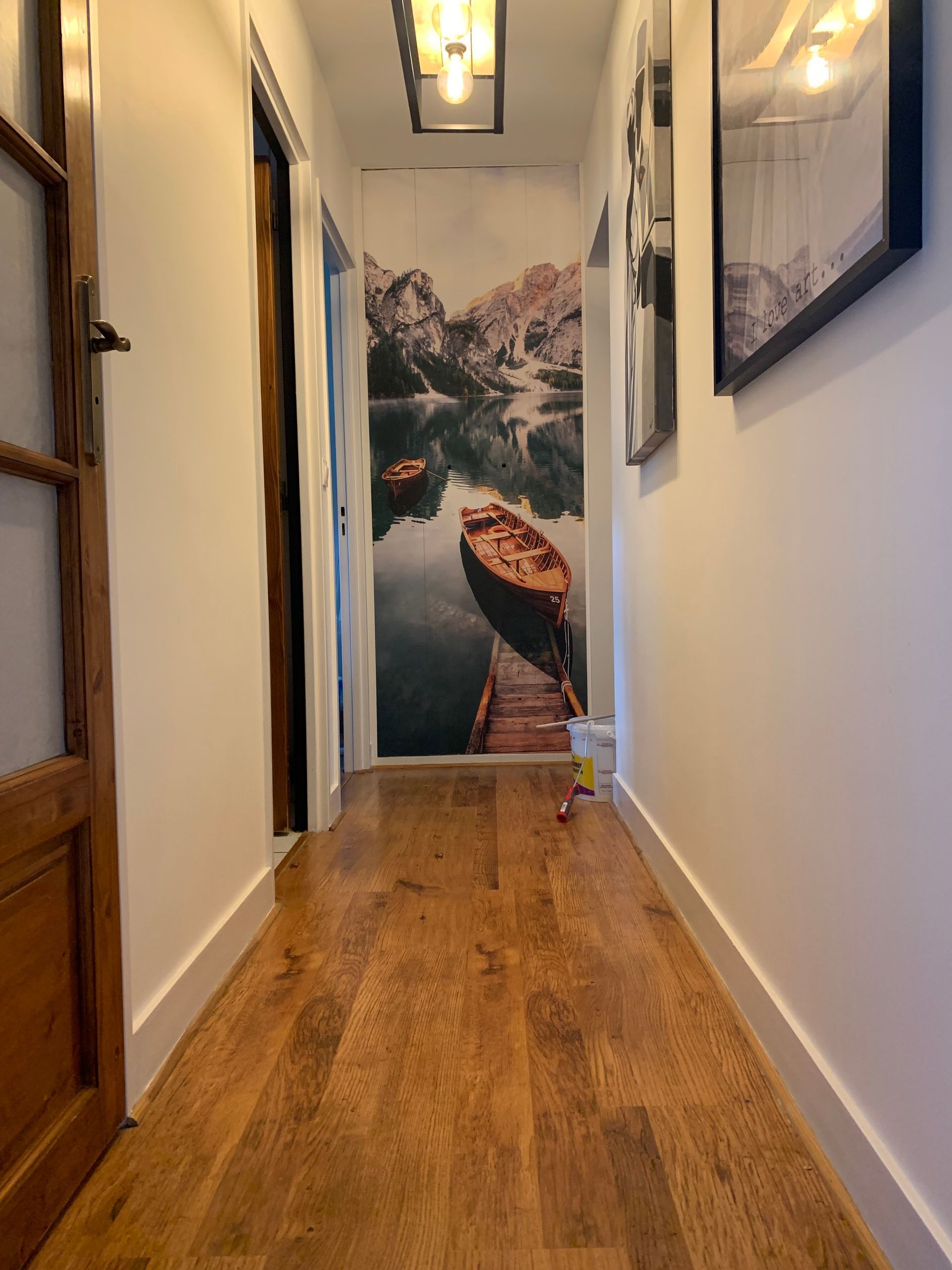 Application sur un mur au bout d'un couloir d'une toile complète d'un paysage d'une barque sur un loch dans les montagnes
