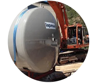 Un gran tanque blanco está sentado al lado de una gran excavadora naranja.
