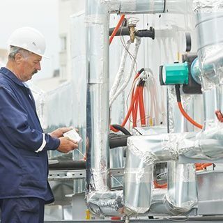 Un hombre que lleva un casco está trabajando en una máquina.