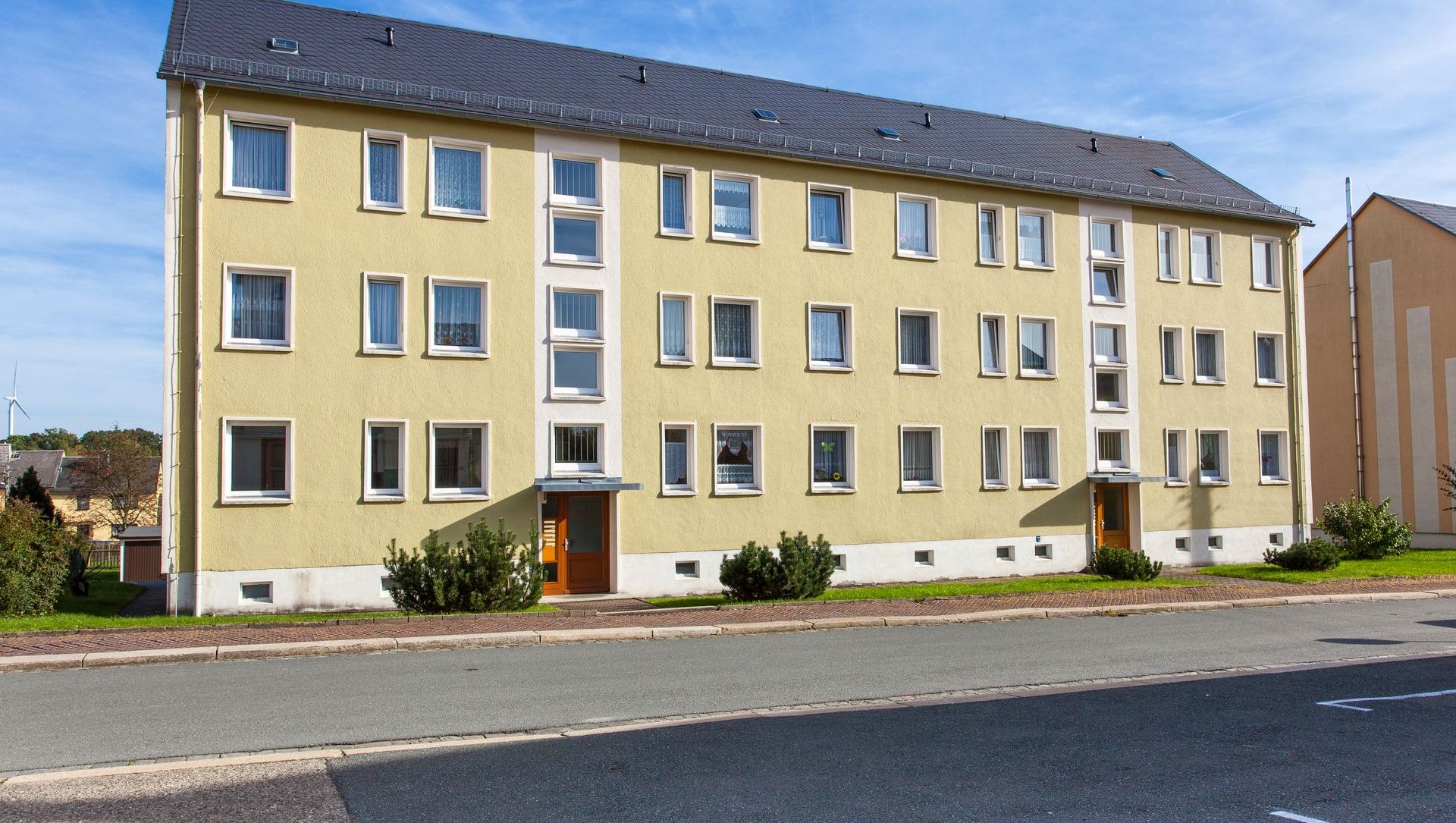 gelbes Wohngebäude der AWG in Pausa
