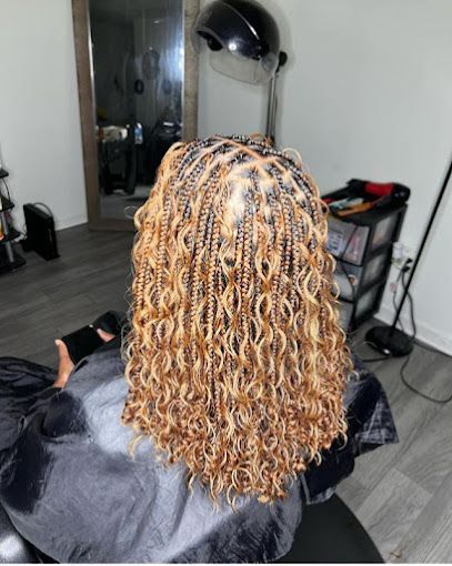 Una mujer está sentada en una silla con el cabello trenzado.